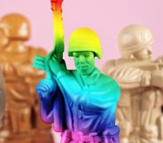 A rainbow toy army man next to a set of beige army men.