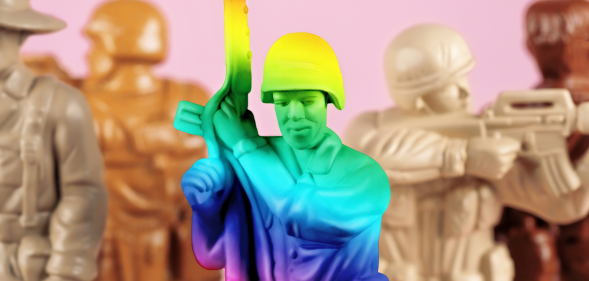 A rainbow toy army man next to a set of beige army men.