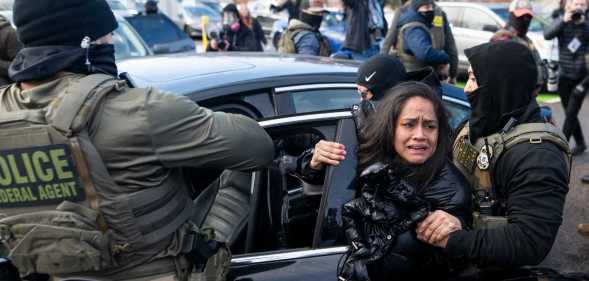 ICE agents detain a woman after pulling her from a car on 13 January, 2026 in Minneapolis, Minnesota.