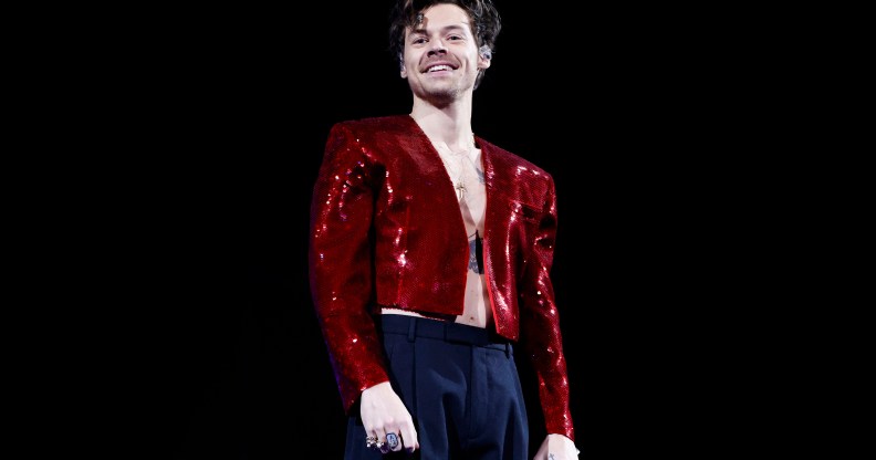 Harry Styles on tour in a shiny red jacket