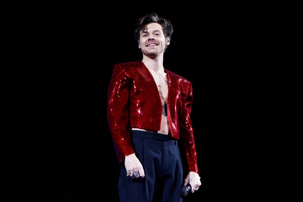 Harry Styles on tour in a shiny red jacket