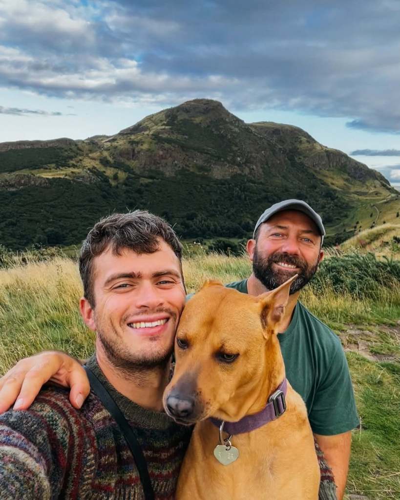 Matthew and his partner, Jason, posing together with their dog on a walk