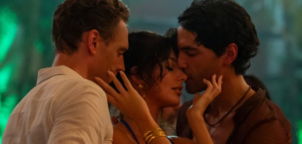 The Night Manager still: Tom Hiddleston as Jonathan Pine, Camila Morrone as Roxana and Diego Calva as Teddy. The three pressed close together dancing