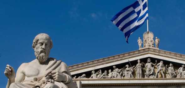 A statue of the ancient Greek philosopher Plato stands outside the Athens Academy.