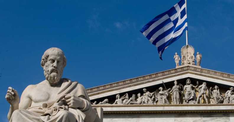 A statue of the ancient Greek philosopher Plato stands outside the Athens Academy.