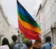 A protest group, with one person holding a Pride flag.