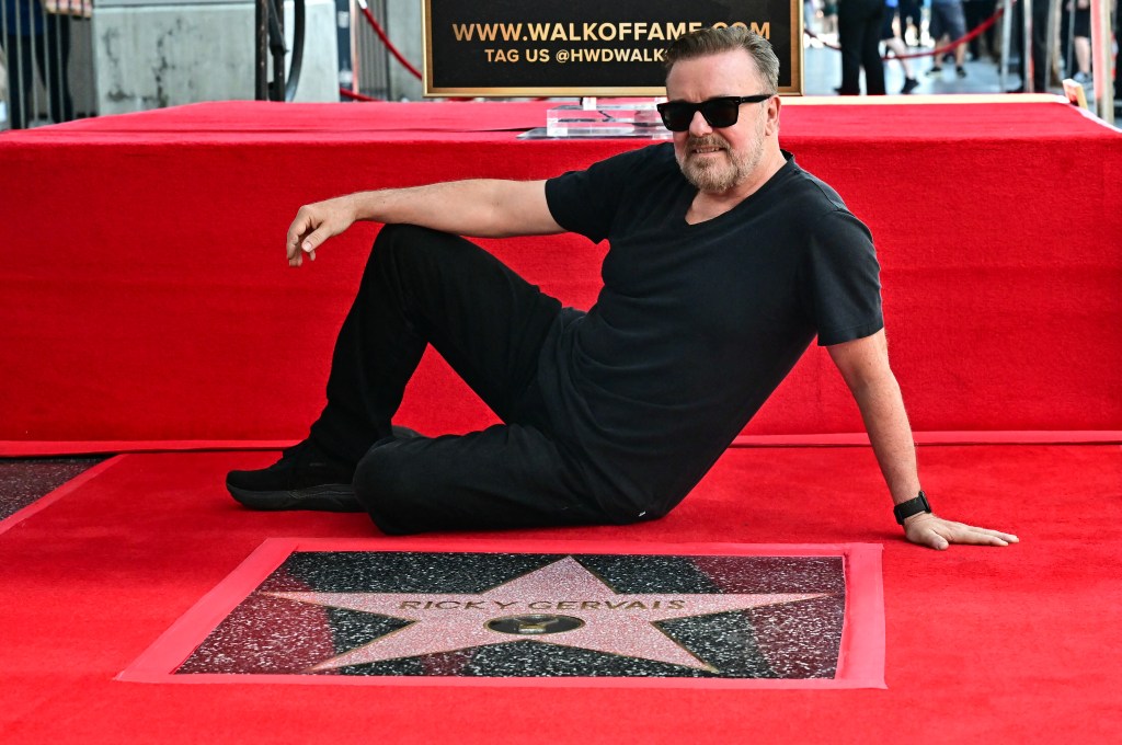 Ricky Gervais posting with his star on the Hollywood Walk of Fame in Hollywood