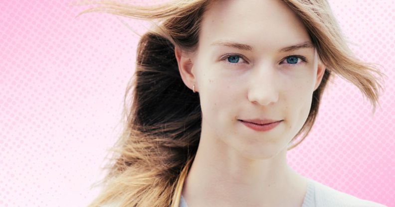 A trans woman superimposed on a pink gradient background.