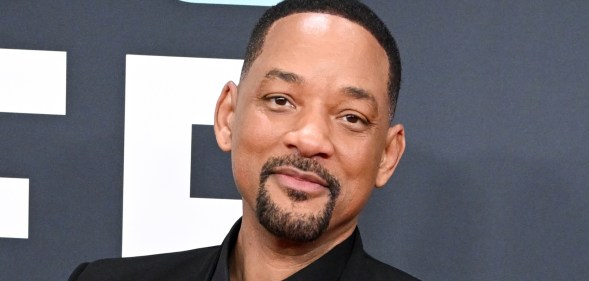 Will Smith at the 67th GRAMMY Awards. Wearing a black suit against a grey backgrop