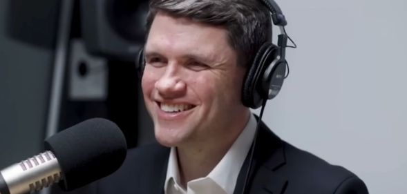 James Talarico, pictured in a recording booth with headphones on.