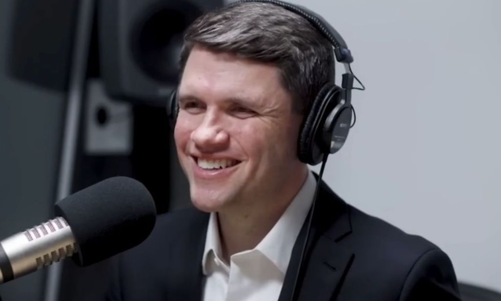 James Talarico, pictured in a recording booth with headphones on.