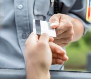 A person handing an officer their license.