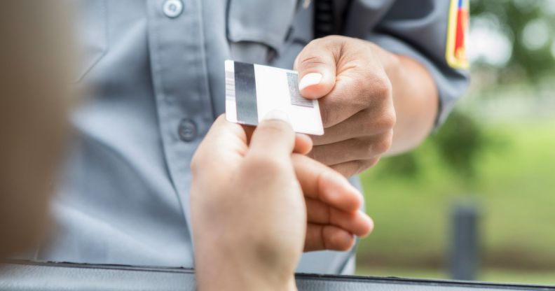 A person handing an officer their license.