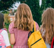 The back profile of three primary-age students.