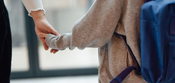 A child holding a mother's hand.