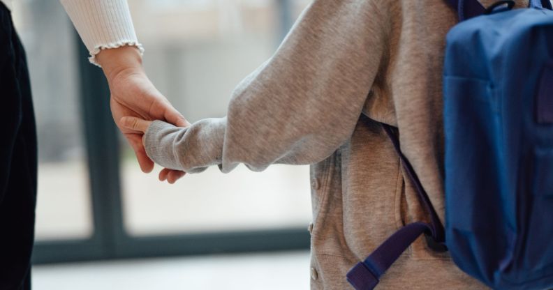 A child holding a mother's hand.