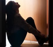 A young person sat pensively in a doorway.