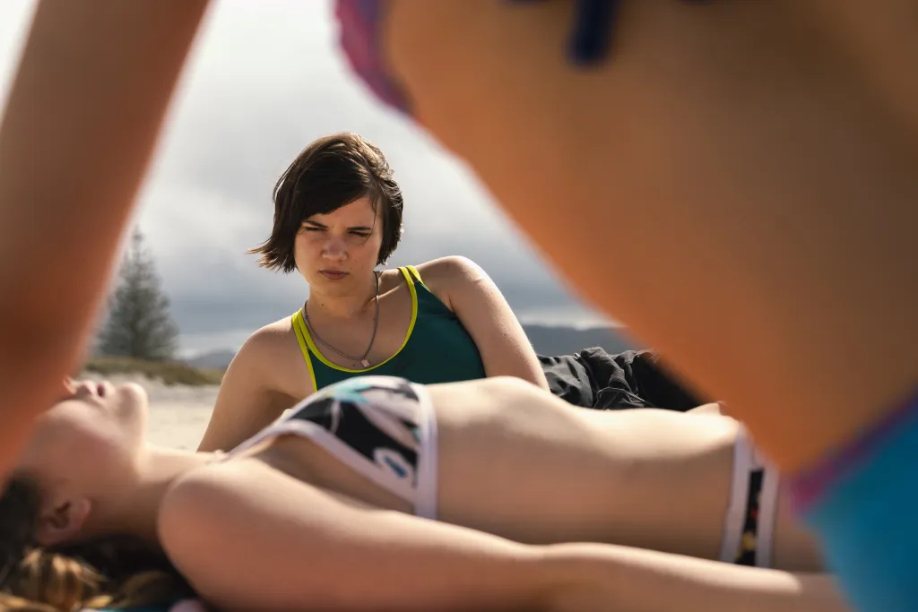 Big Girls Don't Cry still: A teenage girl watching another teen sunbathe on the beach