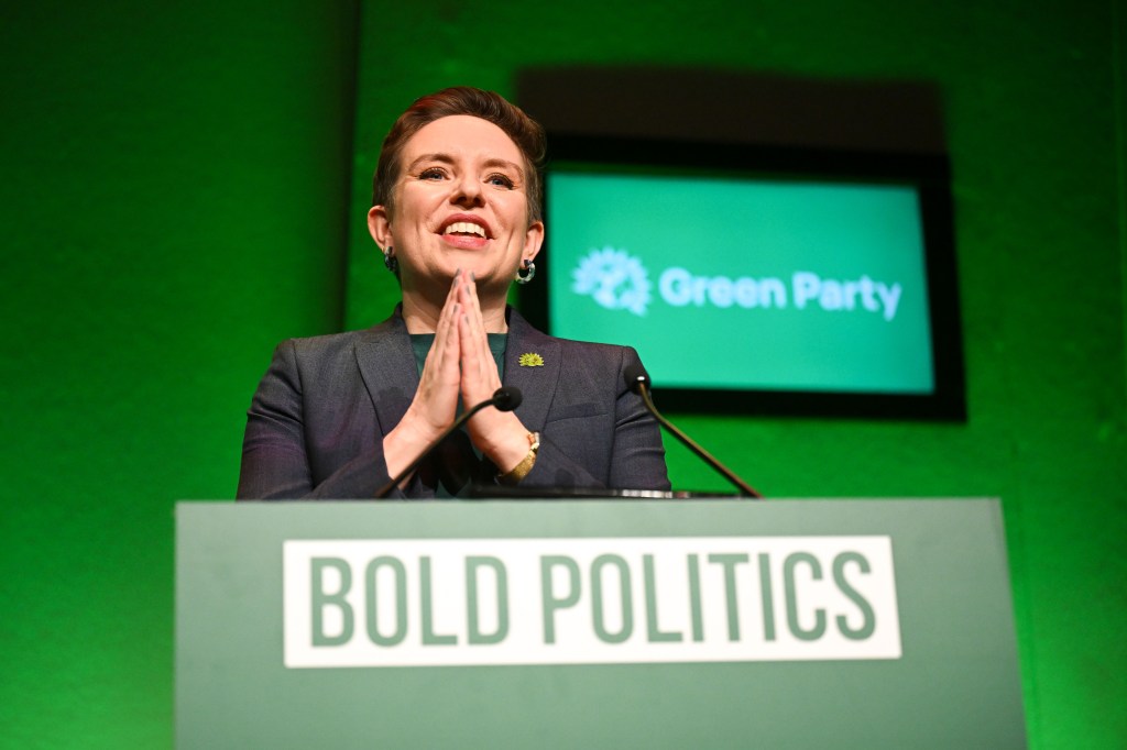 Carla Denyer MP standing at Green Party podium