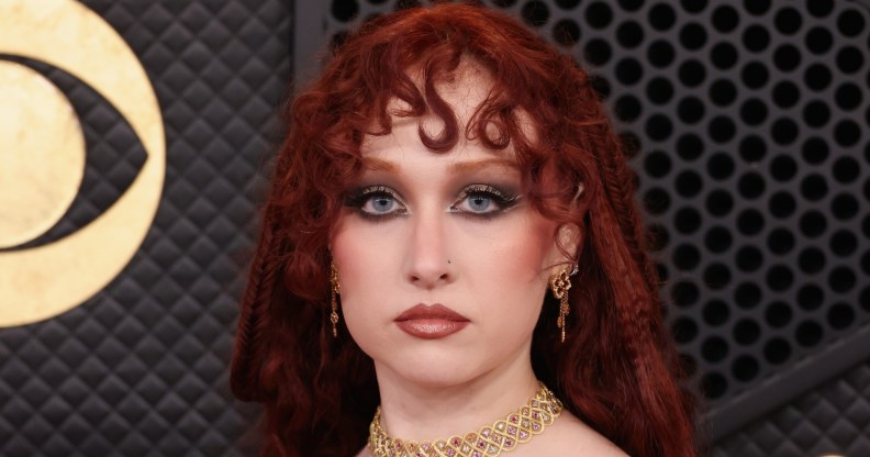 Chappell Roan attends the 68th GRAMMY Awards, wearing a gold choker and a red hood over her hair