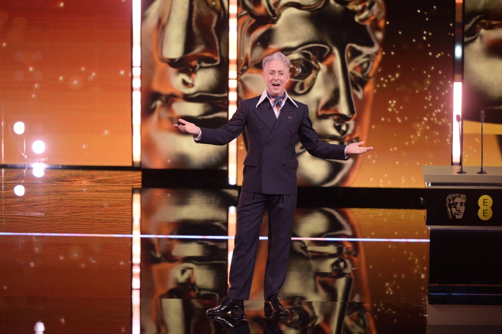 Alan Cumming hosting the BAFTAs. In a dark suit with big pink collar and blue necktie