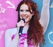 Kate Nash in front of an edited wall with graffiti across it.