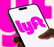 In this photo illustration, a smartphone displays the logo of Lyft Inc. (NASDAQ: LYFT), a major American ride-sharing company, with a blurred version of the company's pink logo visible in the background.