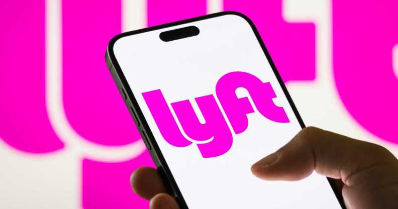 In this photo illustration, a smartphone displays the logo of Lyft Inc. (NASDAQ: LYFT), a major American ride-sharing company, with a blurred version of the company's pink logo visible in the background.