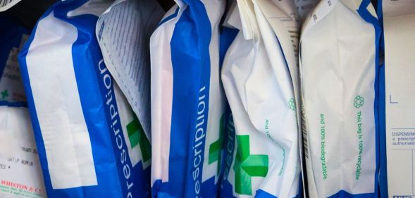 A row of prescription bags in a pharmacy.