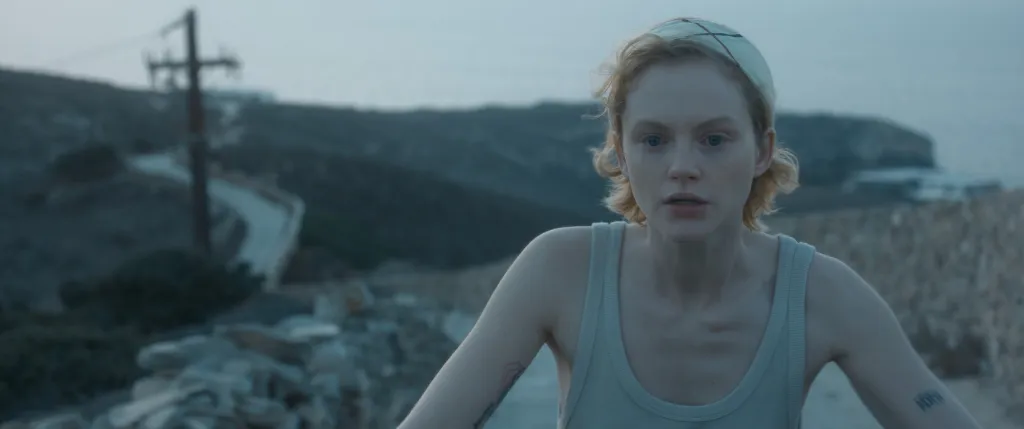 Satisfaction frame of Emma Laird cycling a dirt path in a grey vest