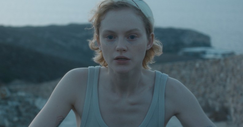 Satisfaction's Emma Laird as Lola, cycling in a vest top by the beach