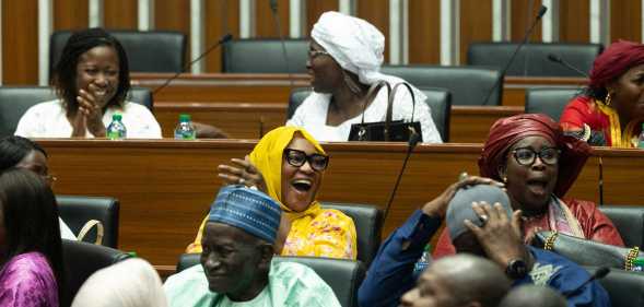 Majority deputies celebrate after the adoption of a law doubling the penalties for homosexuality at the National Assembly in Dakar.