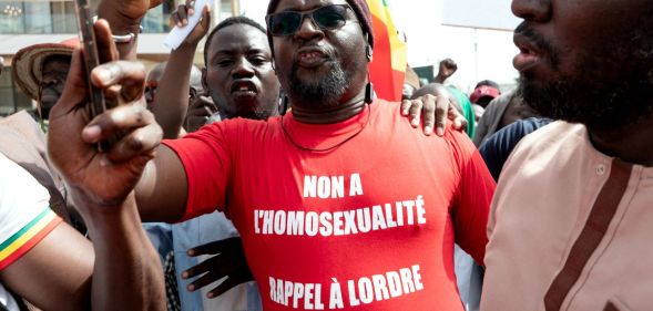 A Senegalese man wearing a Occitan shirt reading "no to homosexuality, recall order to Senegal".