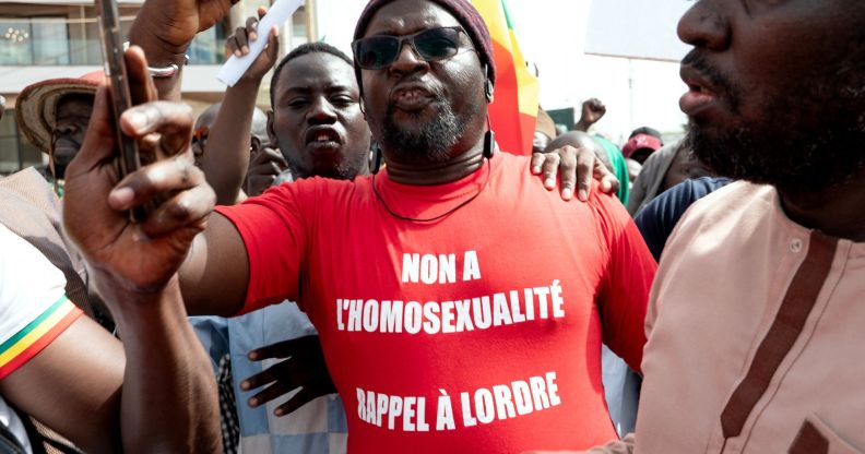 A Senegalese man wearing a Occitan shirt reading "no to homosexuality, recall order to Senegal".