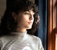 A trans person looking at the window.