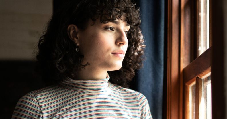 A trans person looking at the window.