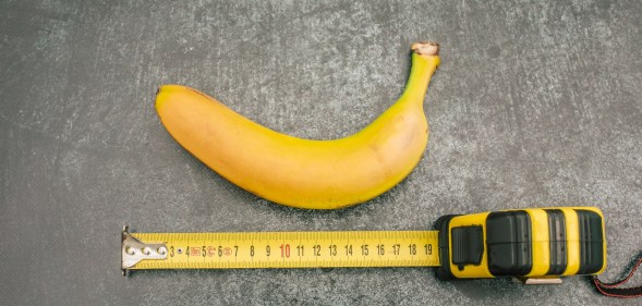 banana on a grey table with a measuring tape below it