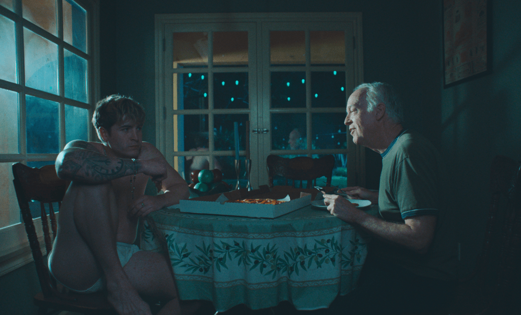 Aaron and Hank sat in the dark with a takeaway pizza on the table.