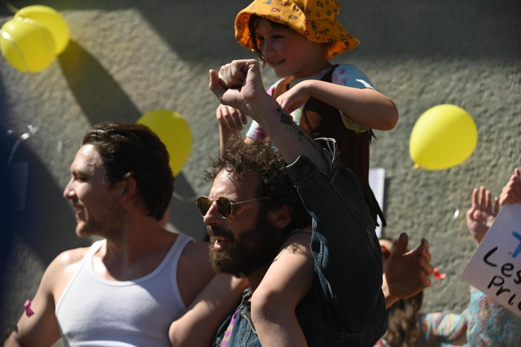 Fairyland still: a little girl on a man's shoulders at a protest