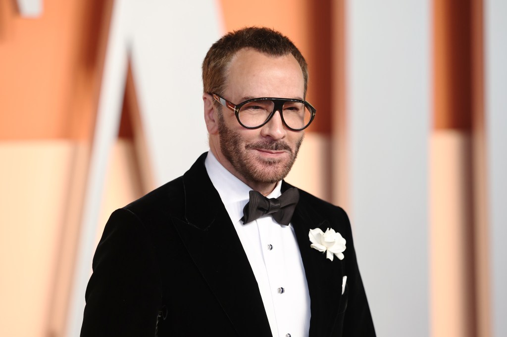Tom Ford in a classic white and black suit. White flower in pocjet and black rimmed glasses