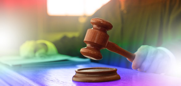 judge's hammer over pride flag colours