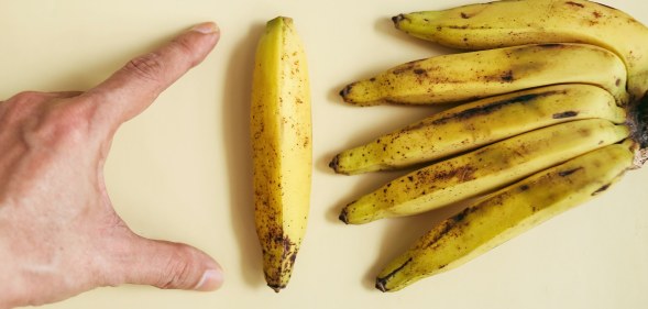 man measuring a banana
