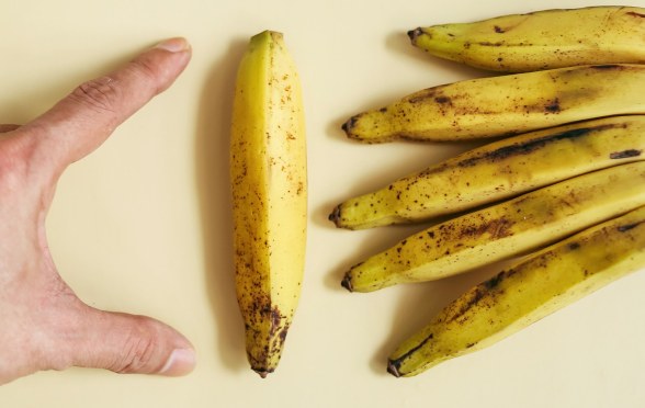 man measuring a banana
