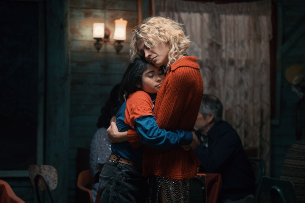 The Mysterious Gaze of the Flamingo still, a child hugging a woman in a cabin.