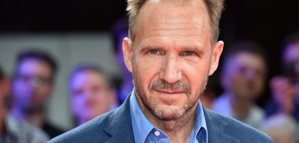 Headshot of Ralph Fiennes wearing a blue shirt and blazer