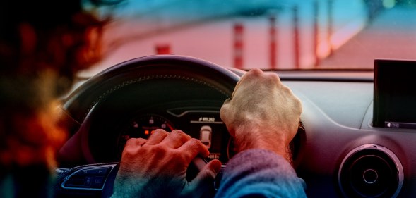 stock image of person driving with trans pride colours
