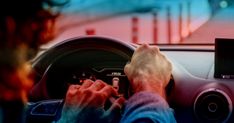 stock image of person driving with trans pride colours