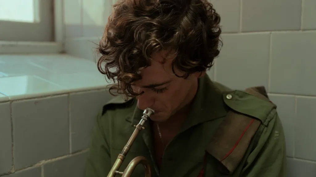 The Black Ball still: a young man in army gear blowing into a trumpet