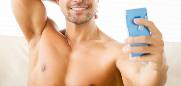 shirtless man using phone