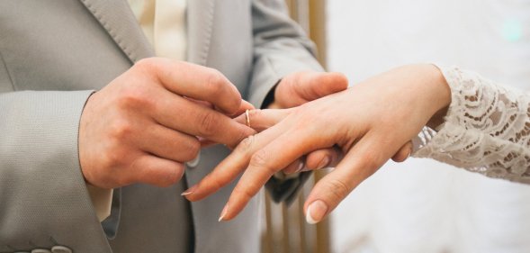 A man and woman exchange rings at a wedding